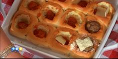 a pan filled with meatballs and cheese on top of a checkered table cloth