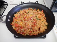 a pan filled with rice and vegetables on top of a stove