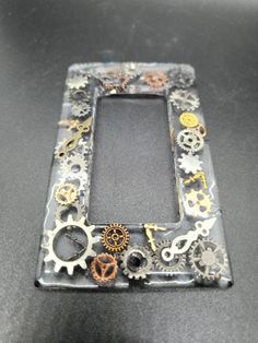 an old cell phone with gears and wheels on the front cover, sitting on a table