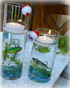 two glass vases filled with water and candles