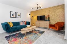 a living room filled with furniture and a flat screen tv on top of a stand