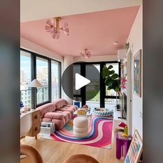 a living room filled with furniture and lots of window sill space next to a pink wall