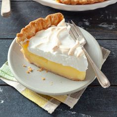 a slice of lemon pie on a plate with a fork and knife next to it