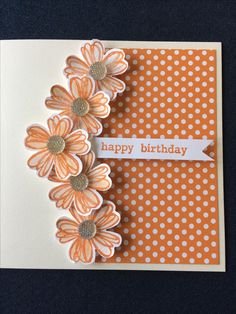 an orange and white birthday card with flowers on the front, and polka dot background