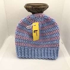 a blue and pink knitted hat with a tag on it