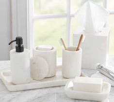 bathroom accessories including soap, toothbrushes and other items on a marble countertop