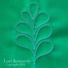 a close up of a green cloth with a stitched tree on the front and bottom