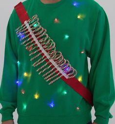 a man wearing a green christmas sweater with lights on it and a red tie around his neck