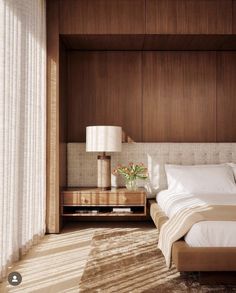 a bed sitting in a bedroom next to a wooden headboard and window sill