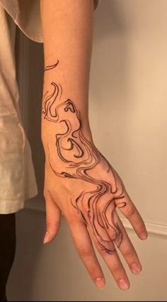 a woman's hand with a tattoo design on the left wrist and right hand