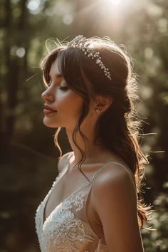 a woman wearing a tiara in the woods with sunlight shining through her hair and shoulders