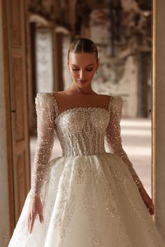 a woman in a white wedding dress is looking down at her hand on the floor