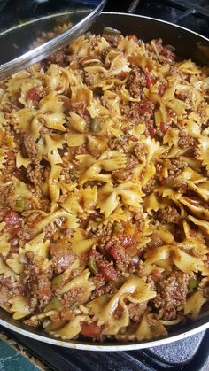 a pan filled with pasta and meat on top of a stove