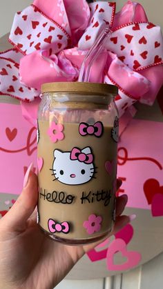 a hand holding a jar with hello kitty on it