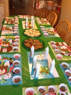 the table is set for christmas dinner with plates and cupcakes