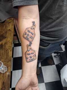 a man with a tattoo on his arm holding onto a clock and date card tattooed on the wrist