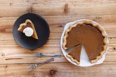 a pie on a plate next to a fork and knife with a piece missing from it