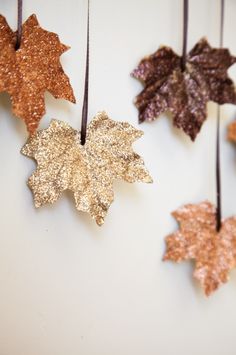 the words charming leaf art ideas are hanging from strings with gold and brown leaves on them