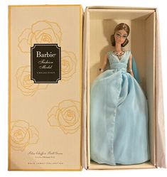 a barbie doll in a blue dress is in a box