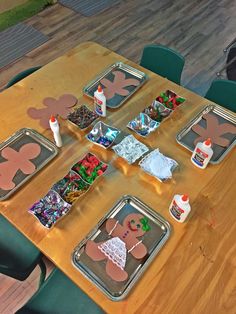 a wooden table topped with lots of trays filled with different types of food and decorations