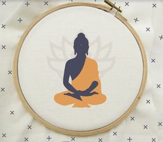 the silhouette of a woman sitting in a lotus position on a white background with blue and orange cross stitchs