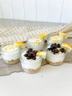 four small mason jars filled with lemon and blueberries