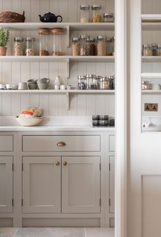 a kitchen with white cabinets and open shelves