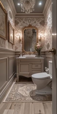 a bathroom with a white toilet sitting next to a sink and a mirror on the wall