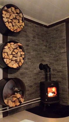 there is a wood stove in the corner of this room with logs on the wall