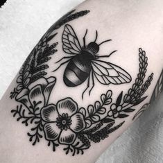 a black and white photo of a bee with flowers on it's back shoulder