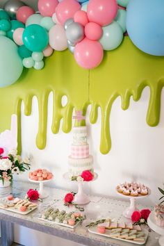 a table topped with lots of desserts and balloons