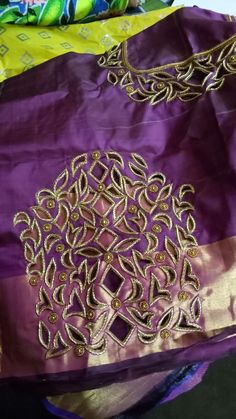 a purple and gold colored saree with intricate designs on the border, along with other fabrics