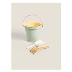 an ice cream bucket with two scoops and three plastic spoons next to it