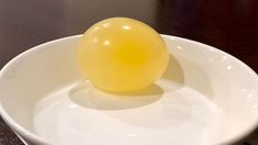 an orange sitting on top of a white bowl