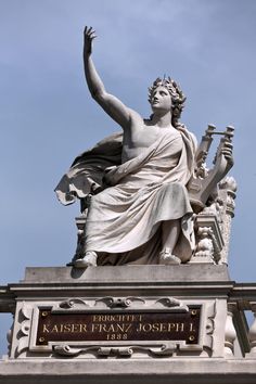 the statue is in front of a blue sky and has a name plate on it