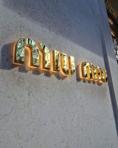 the letters on the wall are made out of metal and have gold trimmings