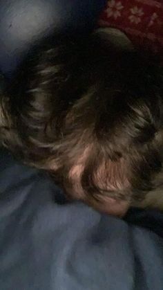 a young boy laying in bed with his head on the pillow