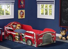 a child's fire truck bed in a room with blue walls and flooring