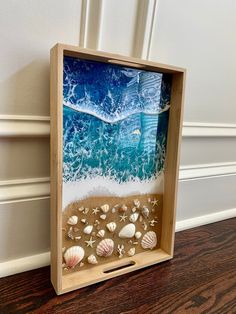 an ocean scene made out of wood with seashells