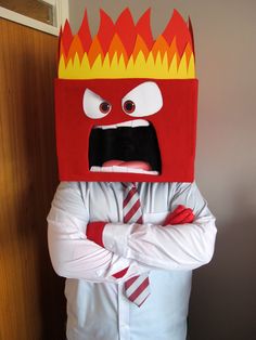 a man wearing a red and yellow mask with flames on it's head is standing in front of a door