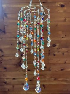 a multicolored chandelier hanging from the ceiling in front of a wooden wall