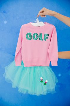 a pink golf sweater and tutu skirt hanging on a clothes line