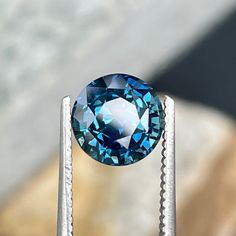 a blue diamond sitting on top of a piece of metal