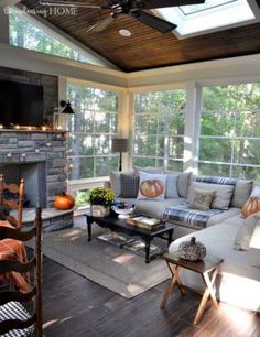 a living room filled with furniture and a fire place under a window covered in fall decorations