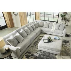 a living room with a large sectional couch and ottoman