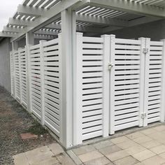 a row of white wooden fences next to a building