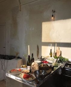 the kitchen counter is covered with food and wine