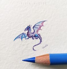 a drawing of a dragon on paper with a blue pencil