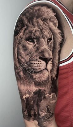 a man's arm with a lion tattoo on it and an elephant in the background