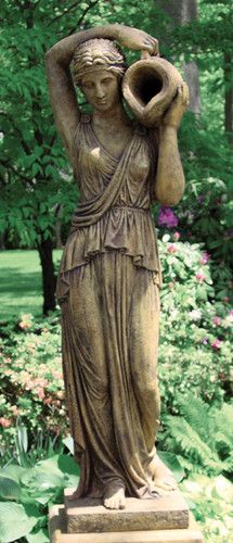 a statue in the middle of a garden holding a vase with her hands on it's head